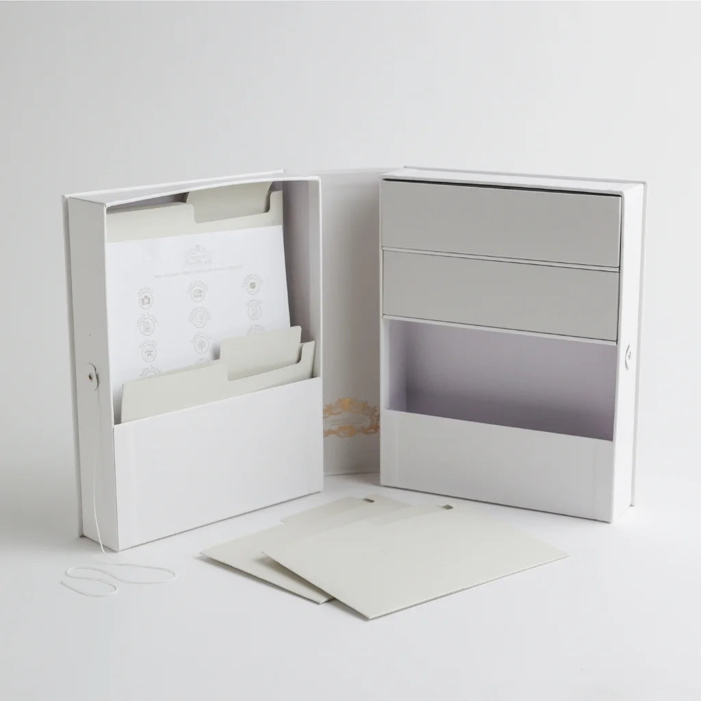 An open view of the baby keepsake organizer, showcasing multiple compartments, storage drawers, and labeled folders for preserving important baby milestones.