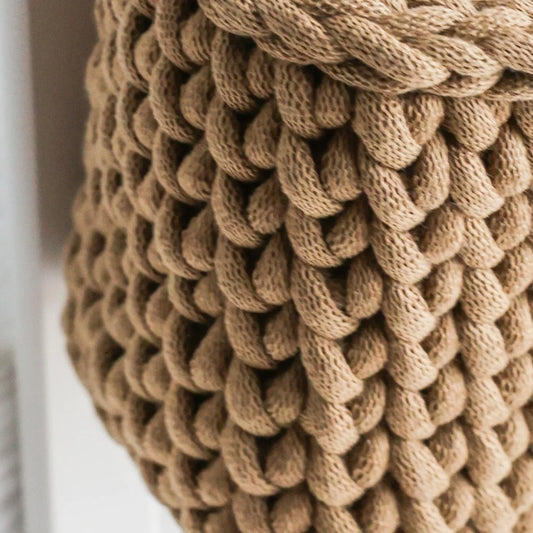A detailed close-up of the thickly woven texture of the brown knit crib organizer, highlighting its premium organic cotton material and durable craftsmanship.