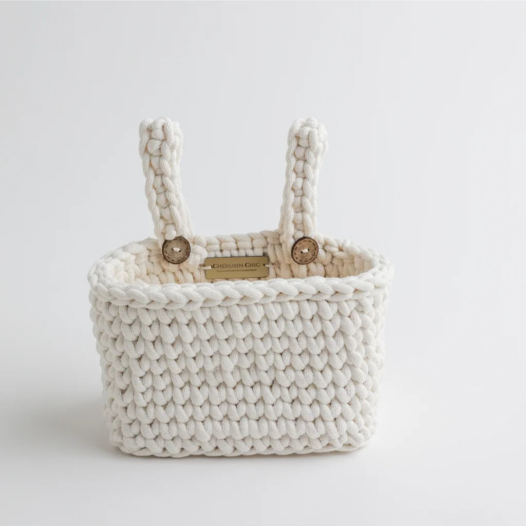 A close-up of a Cherubin Chic branded white knit crib organizer with premium craftsmanship, showcasing its intricate braided texture and sturdy design.