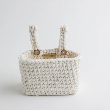 A close-up of a Cherubin Chic branded white knit crib organizer with premium craftsmanship, showcasing its intricate braided texture and sturdy design.