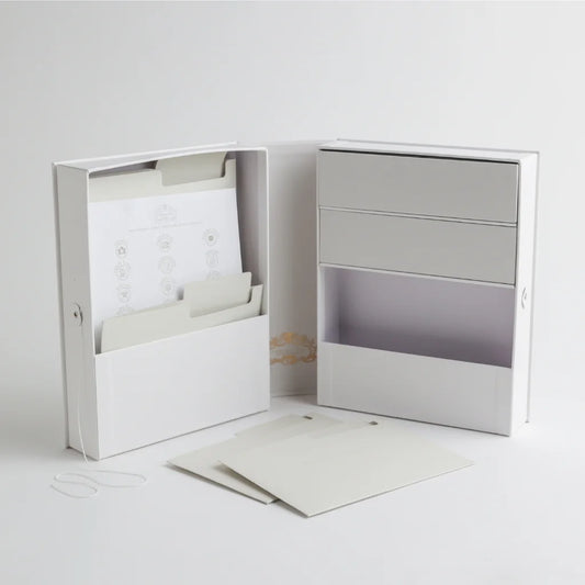 An open view of the baby keepsake organizer, showcasing multiple compartments, storage drawers, and labeled folders for preserving important baby milestones.