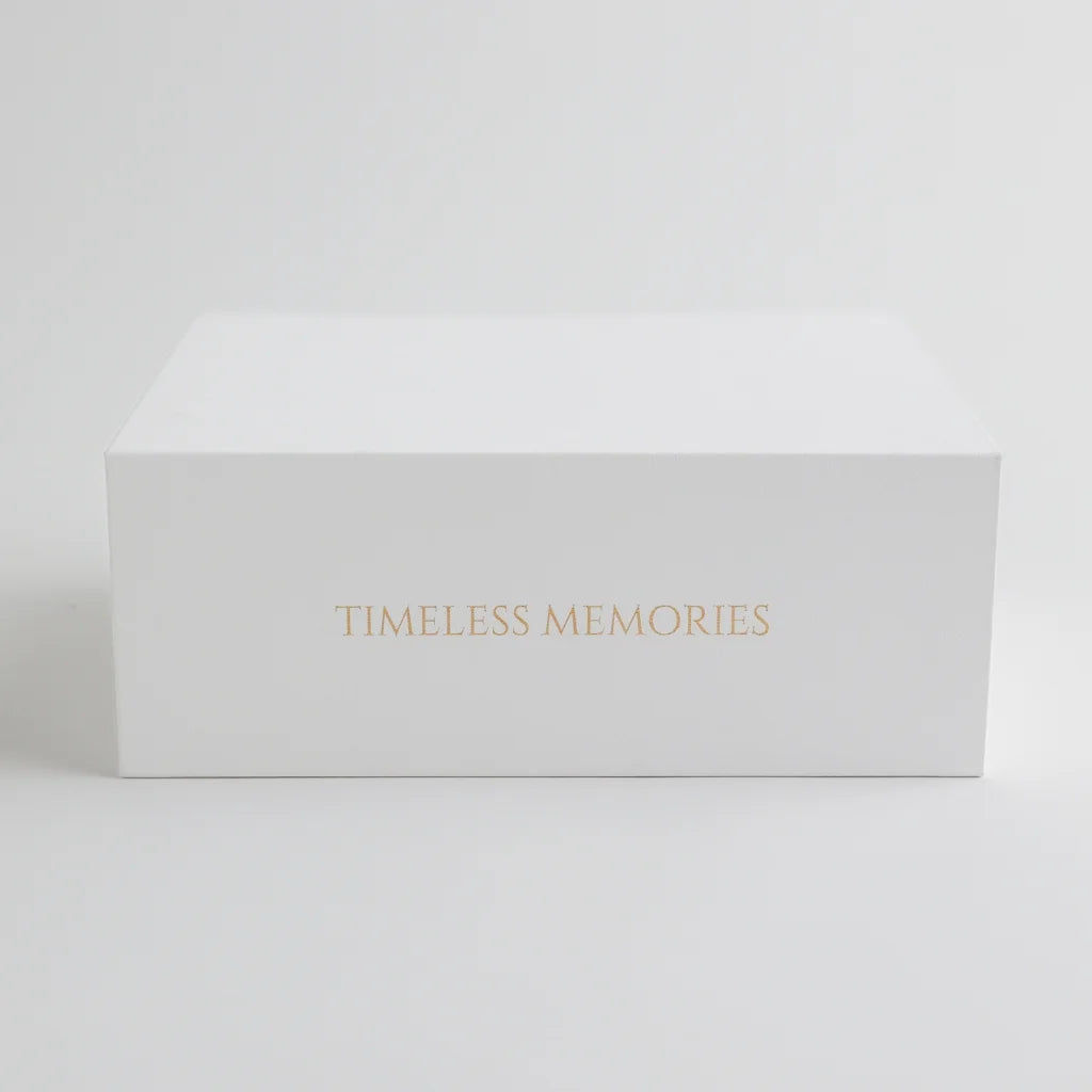 A sleek white keepsake box with "Timeless Memories" elegantly embossed in gold, designed for preserving baby's most treasured moments.