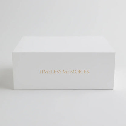 A sleek white keepsake box with "Timeless Memories" elegantly embossed in gold, designed for preserving baby's most treasured moments.