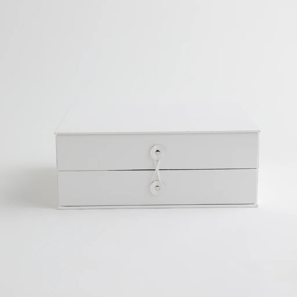 A classic white keepsake storage box with a secure string closure, offering a sophisticated and organized way to store baby’s milestones.