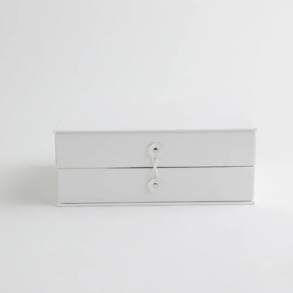 A classic white keepsake storage box with a secure string closure, offering a sophisticated and organized way to store baby’s milestones.