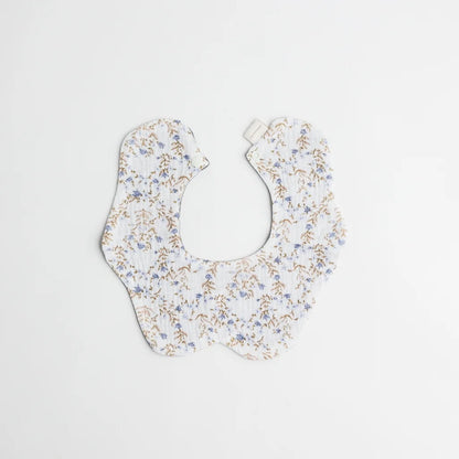 A charming baby bib adorned with a delicate blue and beige floral pattern, designed with premium organic cotton for comfort and style.