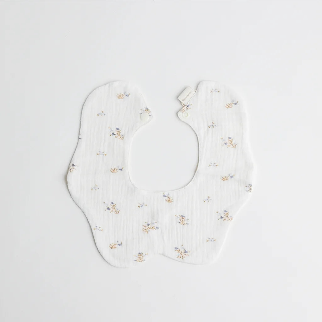 A full display of the Cherubin Chic soft double-sided baby bib collection in elegant pastel tones, arranged beside a keepsake gift box.