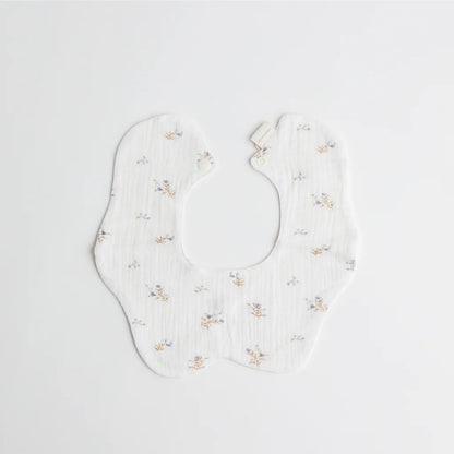 A full display of the Cherubin Chic soft double-sided baby bib collection in elegant pastel tones, arranged beside a keepsake gift box.