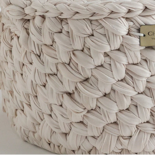 A detailed close-up of the woven knit texture of a Cherubin Chic storage basket in beige, highlighting the intricate braiding and craftsmanship.