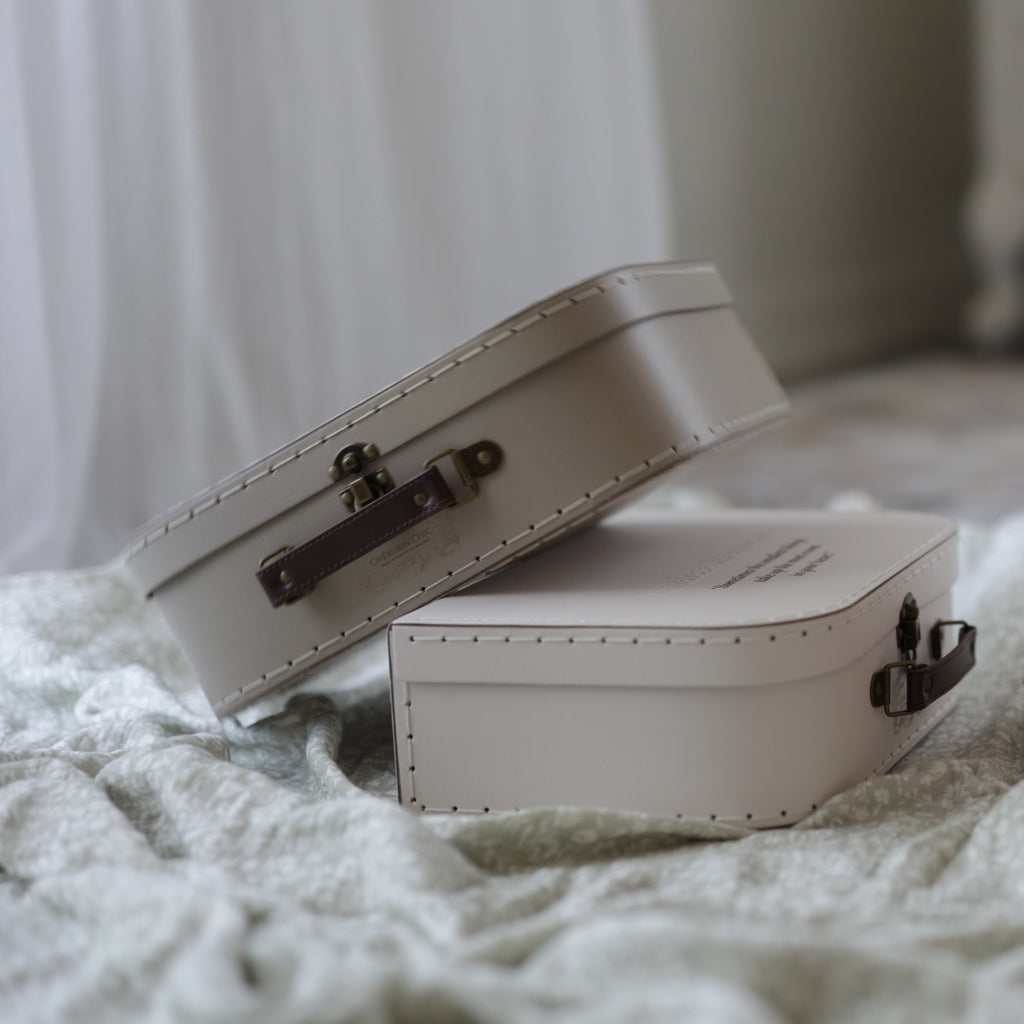 Two vintage memory suitcases placed in a cozy setting with soft lighting, highlighting their elegant craftsmanship and brown leather handles.