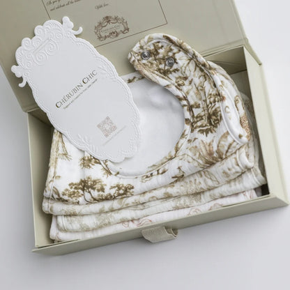 A close-up of a set of luxury muslin baby bibs, neatly packaged in a premium gift box with an elegant Cherubin Chic branding tag.