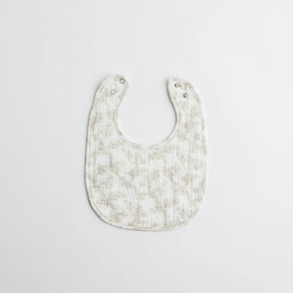 A classic baby bib with an elegant floral print in muted tones. The soft muslin fabric provides gentle protection for a baby's delicate skin.