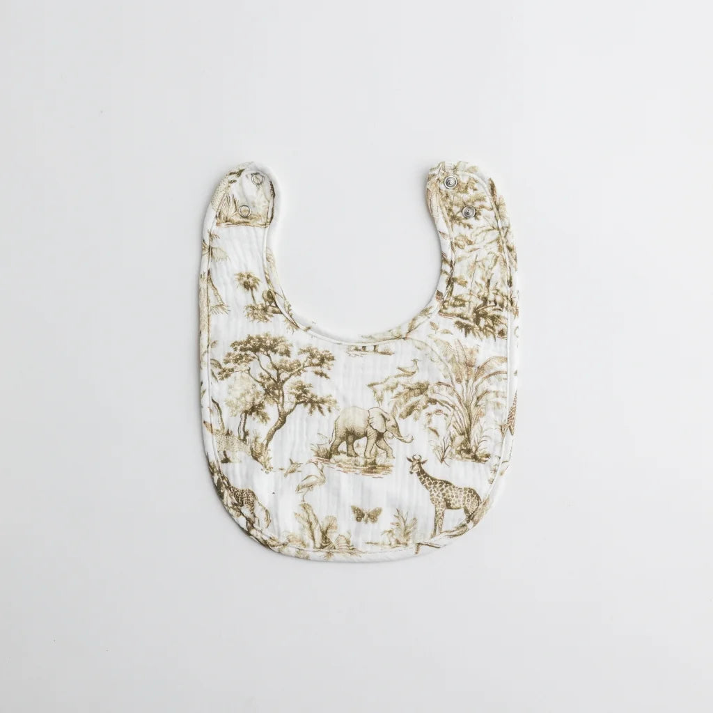 A nature-inspired baby bib featuring a safari-themed print with giraffes, elephants, and lush greenery. Made from soft muslin fabric for comfort and absorbency.