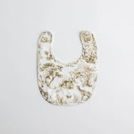 A nature-inspired baby bib featuring a safari-themed print with giraffes, elephants, and lush greenery. Made from soft muslin fabric for comfort and absorbency.