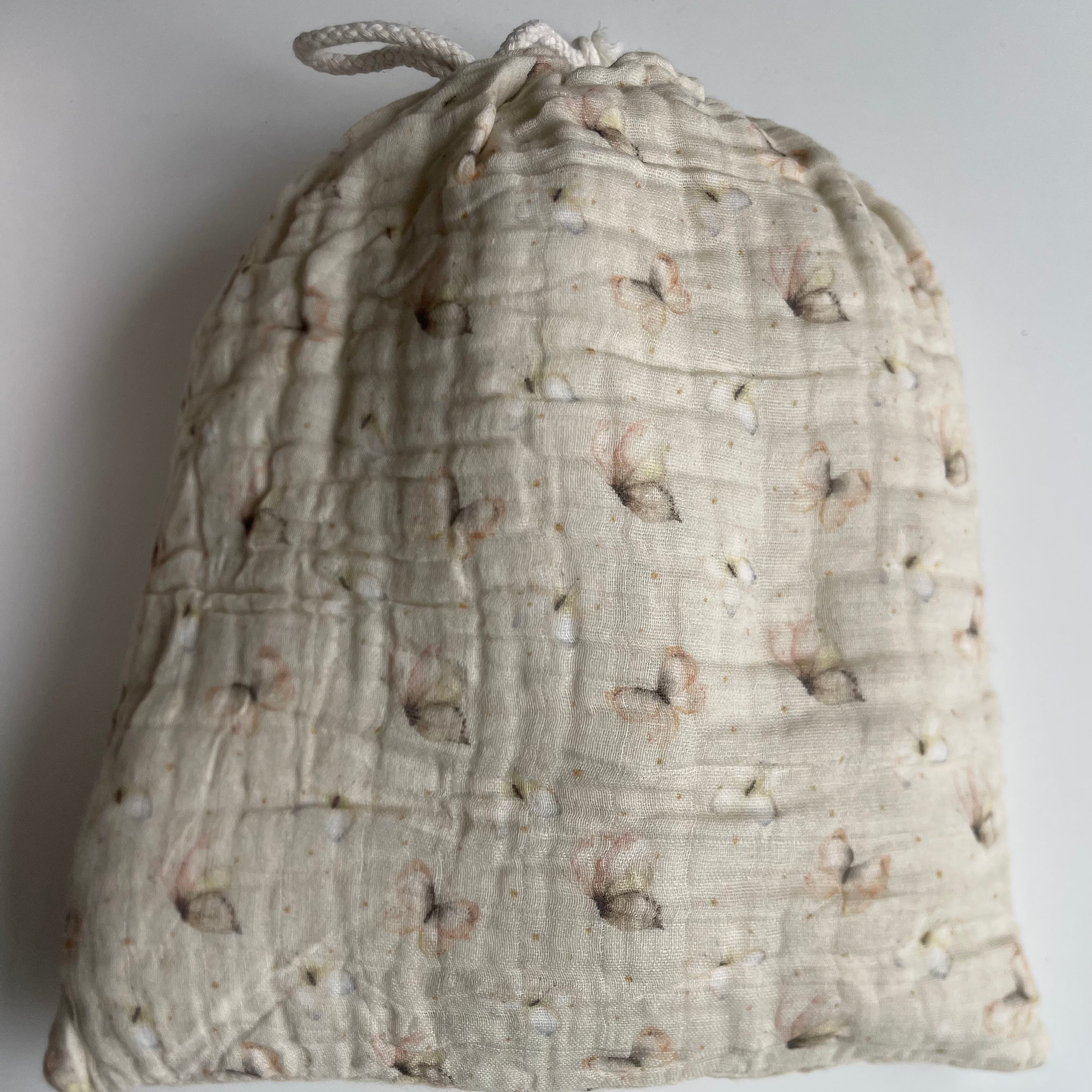 Textured fabric drawstring bag on a plain background
