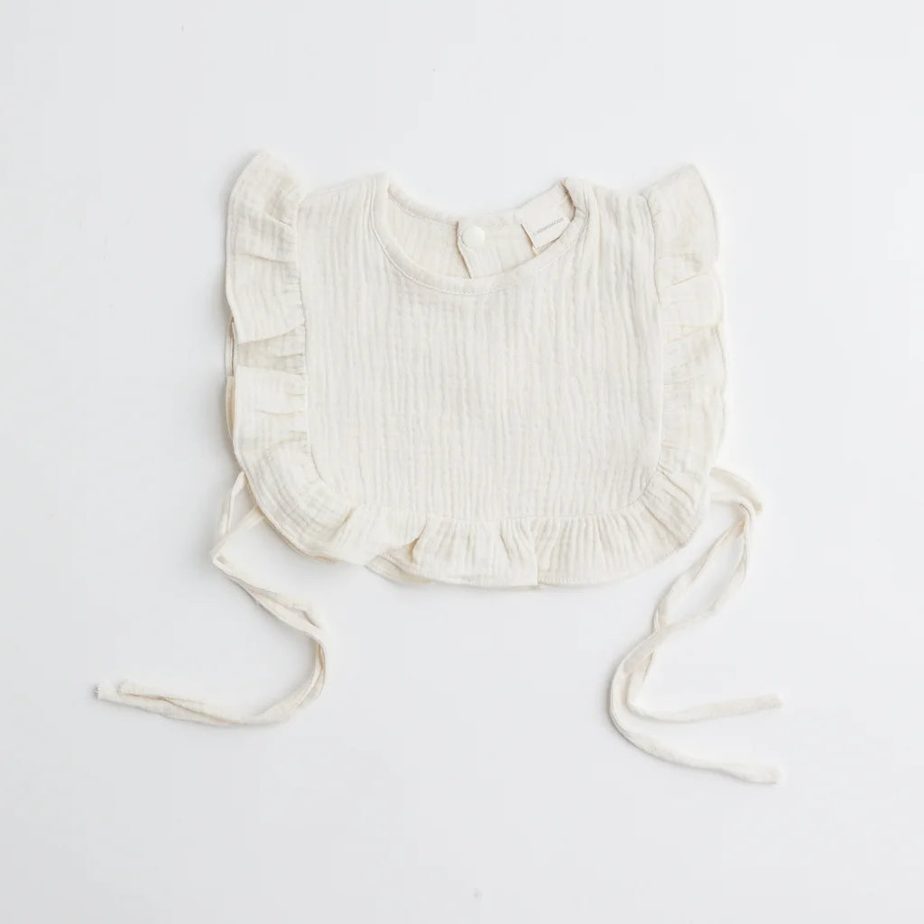 A classic ivory muslin ruffle bib with ruffled trim, offering an elegant and breathable fabric for babies.