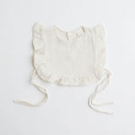 A classic ivory muslin ruffle bib with ruffled trim, offering an elegant and breathable fabric for babies.